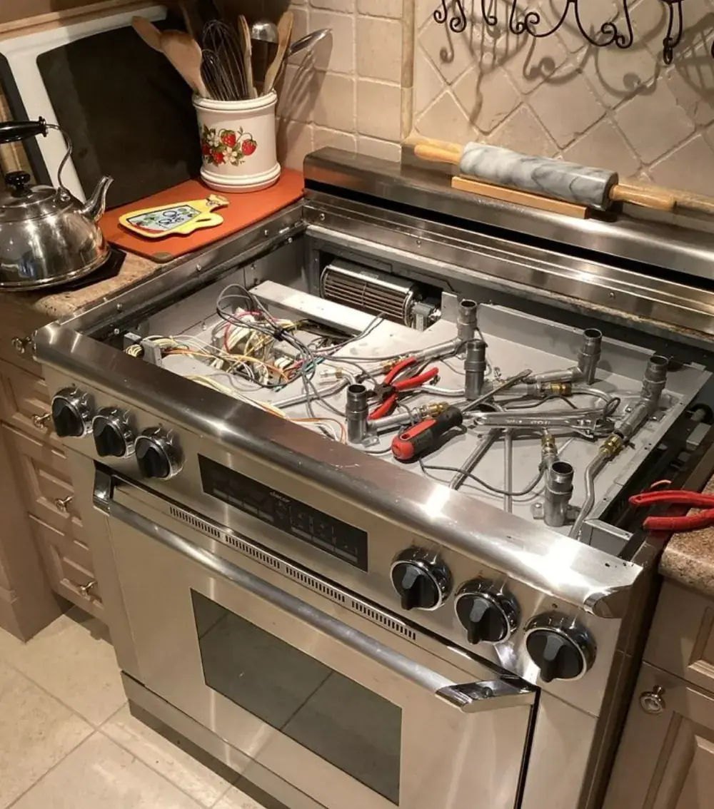 Cooking range opened for internal repair and component inspection